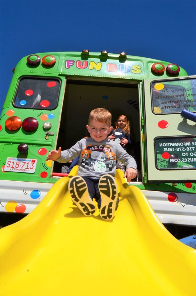 Young boy enjoying the slides with FUN BUS's mobile franchise.