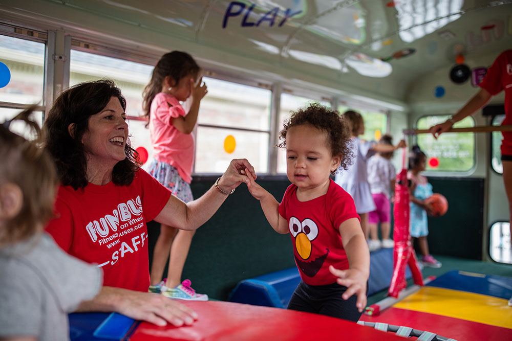 A girl crawling through a tube enjoys FUN BUS's kids indoor play franchise.