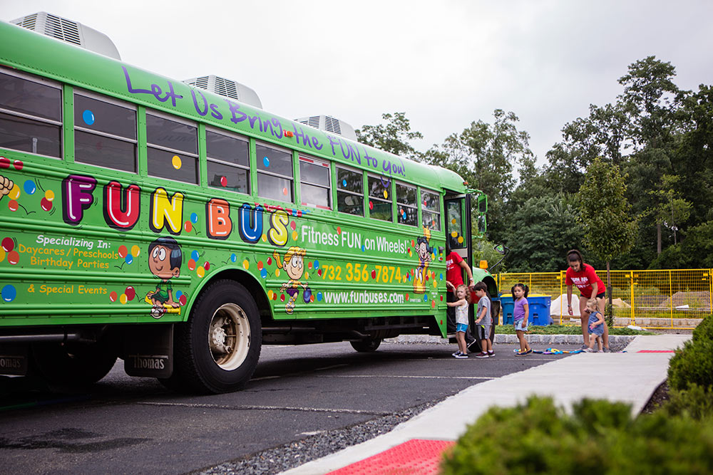 FUN BUS's big, green bus with children and owners.