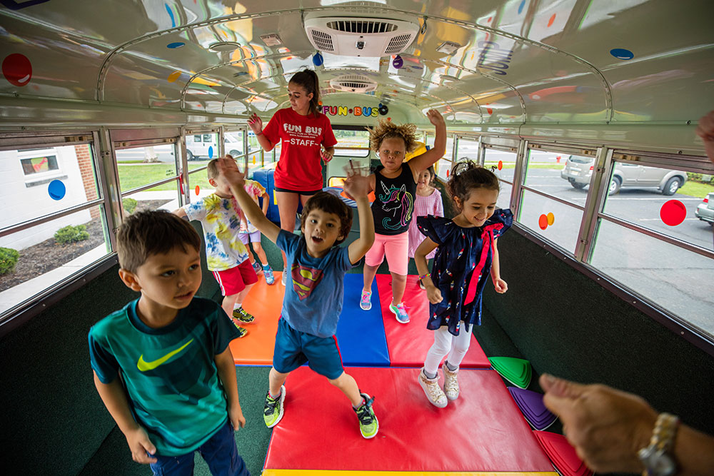 Children playing & learning at a FUN BUS kids gym franchise, where there are no hidden fees.